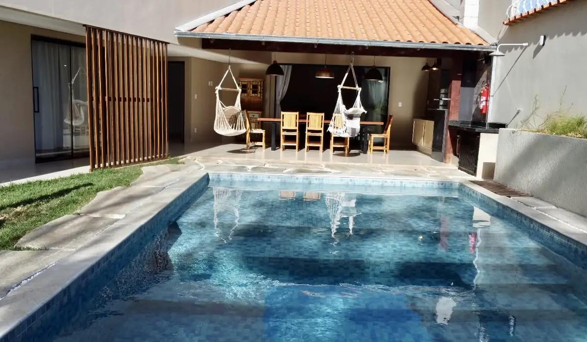 Piscina com área gourmet coberta ao fundo
